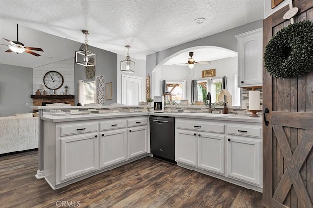 kitchen featuring sink, black dishwasher, kitchen peninsula, lofted ceiling, and white cabinets