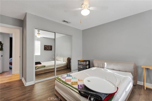 bedroom featuring ceiling fan, a closet, and dark hardwood / wood-style floors