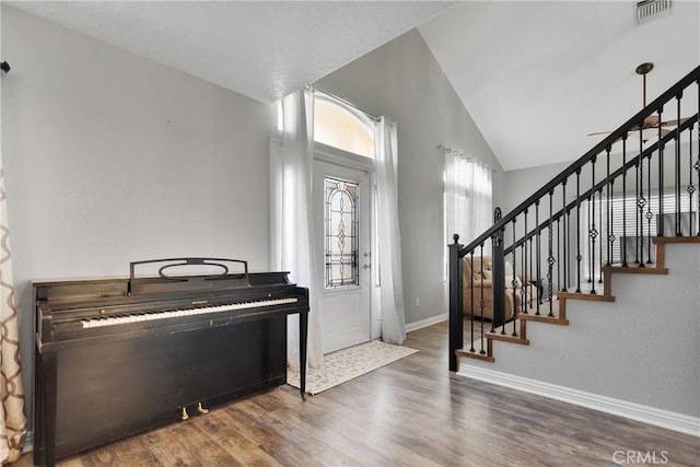 foyer with dark hardwood / wood-style flooring and lofted ceiling