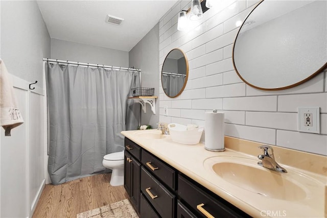 full bathroom featuring vanity, backsplash, toilet, shower / tub combo with curtain, and wood-type flooring