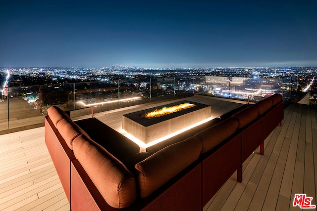 deck at night featuring a fire pit