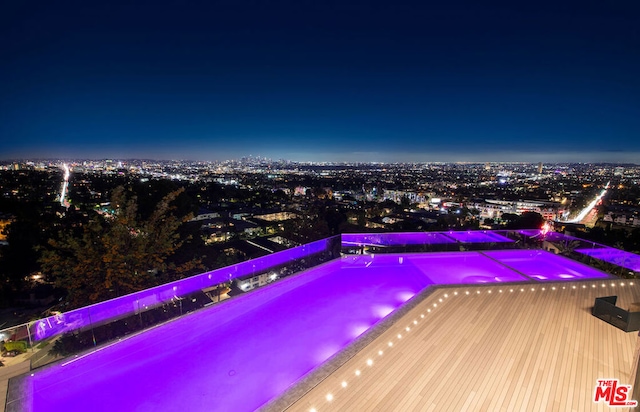 view of pool at twilight