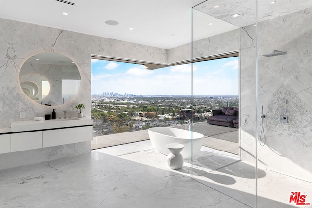 bathroom featuring plus walk in shower, tile walls, plenty of natural light, and vanity