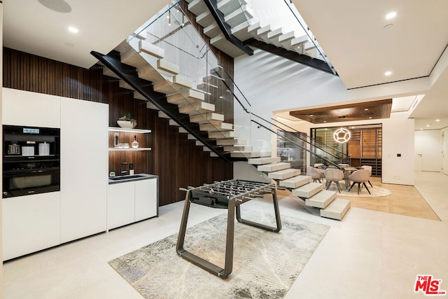 stairs with wooden walls and a towering ceiling