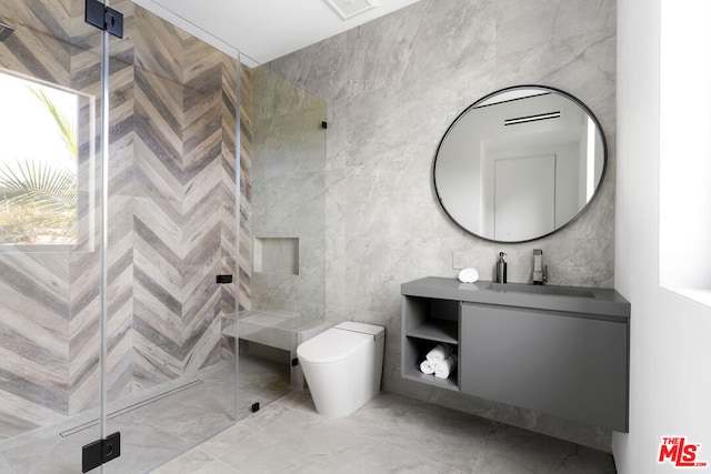 bathroom with vanity, tile walls, toilet, and a shower with door