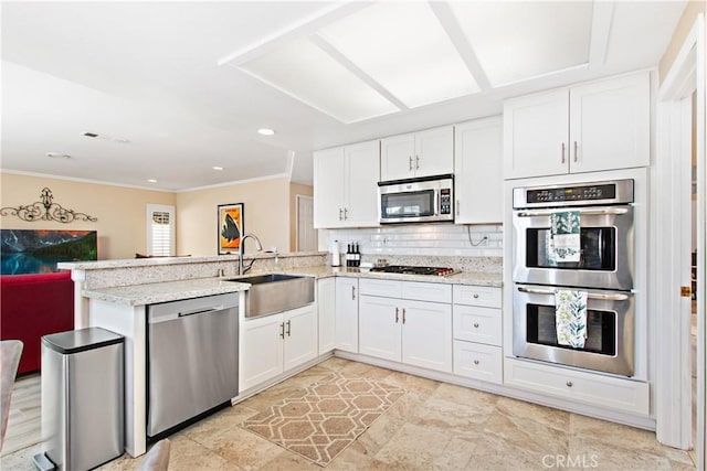 kitchen with white cabinets, sink, decorative backsplash, kitchen peninsula, and stainless steel appliances