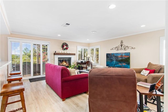 living room with light hardwood / wood-style flooring and ornamental molding