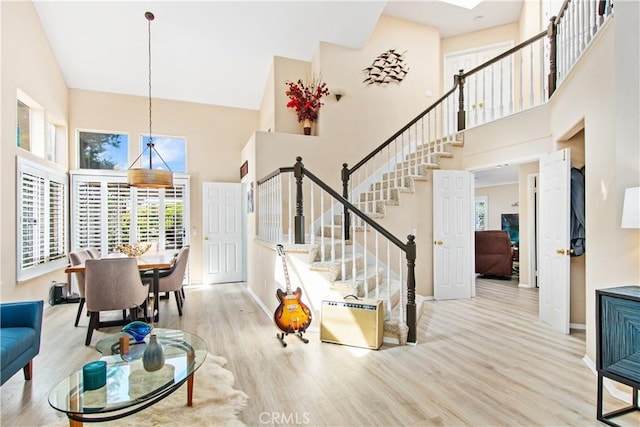 living room with a high ceiling and light hardwood / wood-style flooring