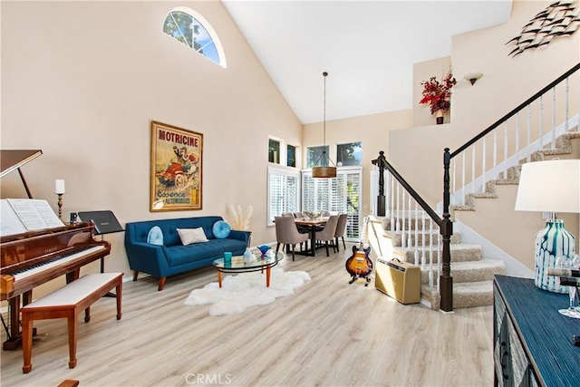 living room featuring light wood-type flooring and a towering ceiling