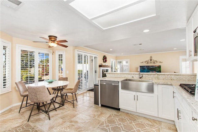 kitchen with light stone counters, sink, white cabinets, and appliances with stainless steel finishes