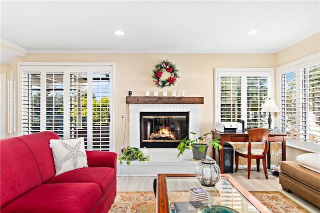 living room with ornamental molding, a fireplace, and light hardwood / wood-style flooring