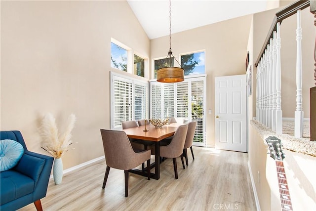 dining room featuring light hardwood / wood-style floors and high vaulted ceiling