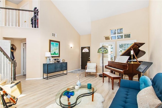 living room featuring a high ceiling and light wood-type flooring