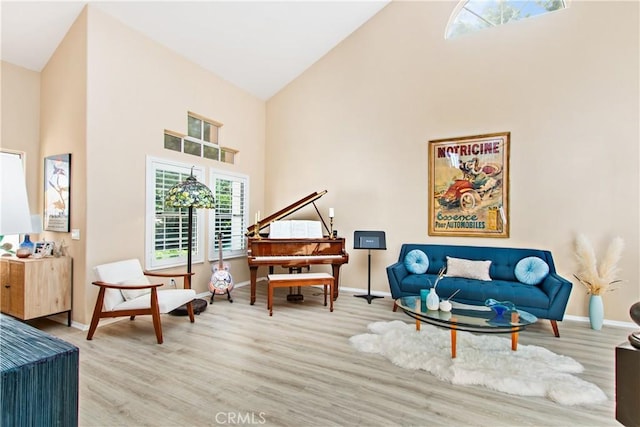 sitting room featuring light wood-type flooring and high vaulted ceiling