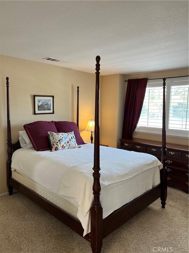 bedroom with light carpet and a textured ceiling