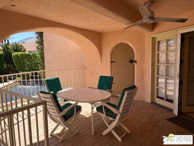 view of patio / terrace featuring a mountain view, ceiling fan, and a balcony