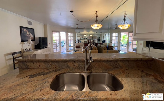 kitchen featuring sink, decorative light fixtures, french doors, and a wealth of natural light