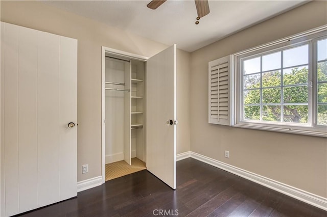 unfurnished bedroom featuring ceiling fan, a closet, and dark hardwood / wood-style floors