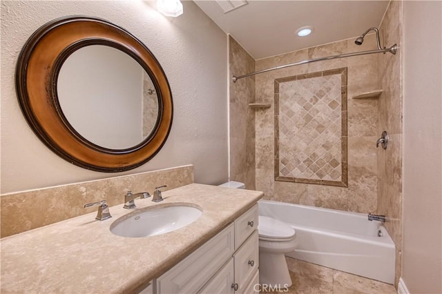 full bathroom with tiled shower / bath, tile patterned floors, vanity, and toilet