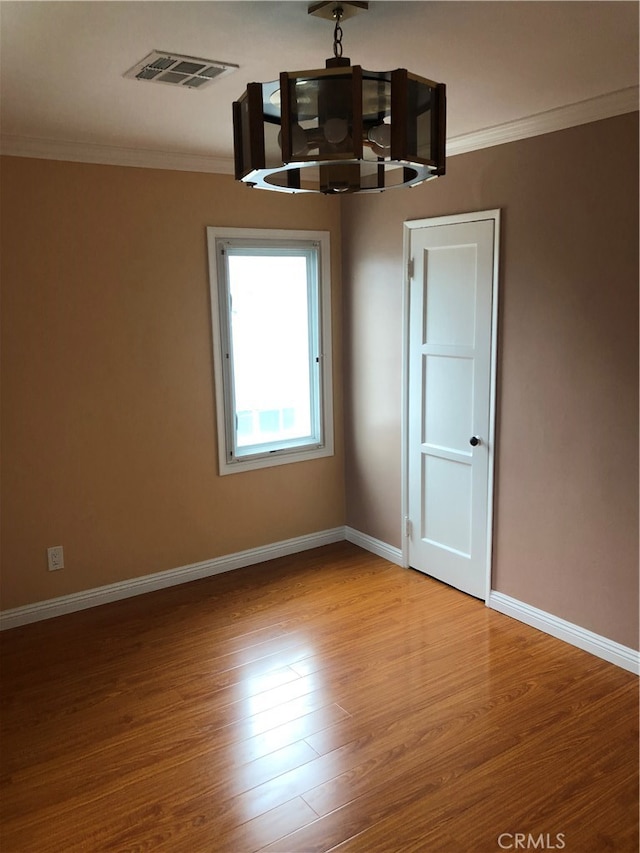 spare room featuring light hardwood / wood-style floors and crown molding