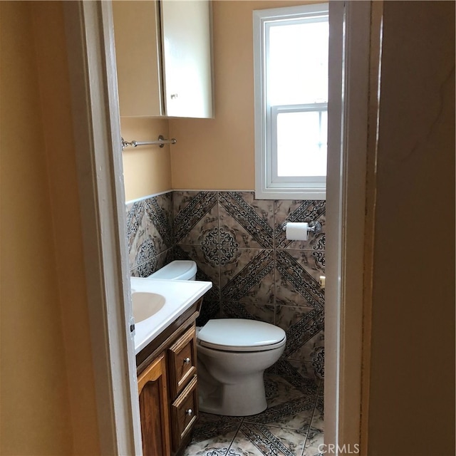 bathroom featuring vanity, tile walls, toilet, and tile patterned floors