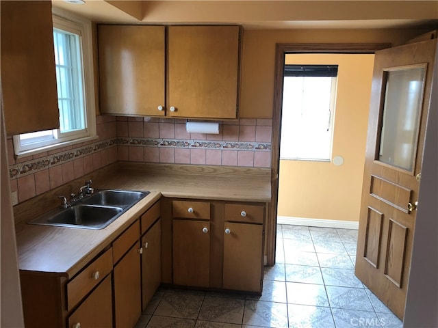 kitchen featuring light tile patterned floors, tasteful backsplash, and sink