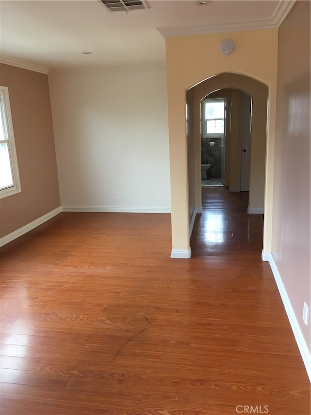 unfurnished room featuring ornamental molding and dark wood-type flooring