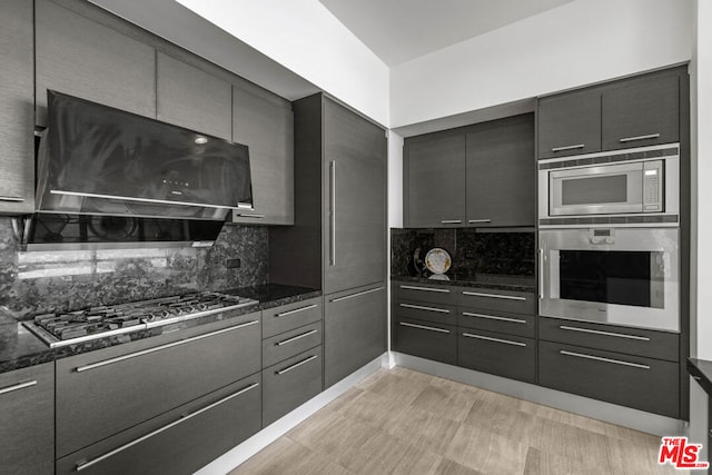 kitchen with dark stone countertops, appliances with stainless steel finishes, and tasteful backsplash