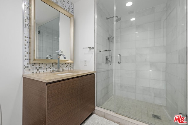 bathroom featuring decorative backsplash, an enclosed shower, and vanity