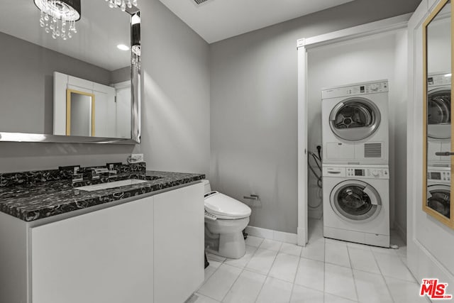 washroom featuring sink, stacked washer / drying machine, and light tile patterned flooring