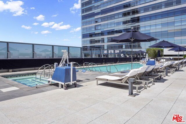 view of pool featuring a community hot tub and a patio area