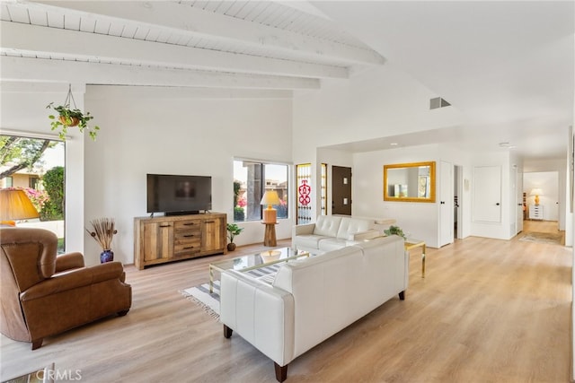 living room with beam ceiling, light wood-type flooring, high vaulted ceiling, and plenty of natural light