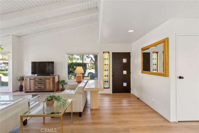 living room featuring lofted ceiling with beams, a healthy amount of sunlight, and light wood-type flooring