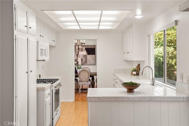 kitchen with stainless steel gas range oven, plenty of natural light, and white cabinets