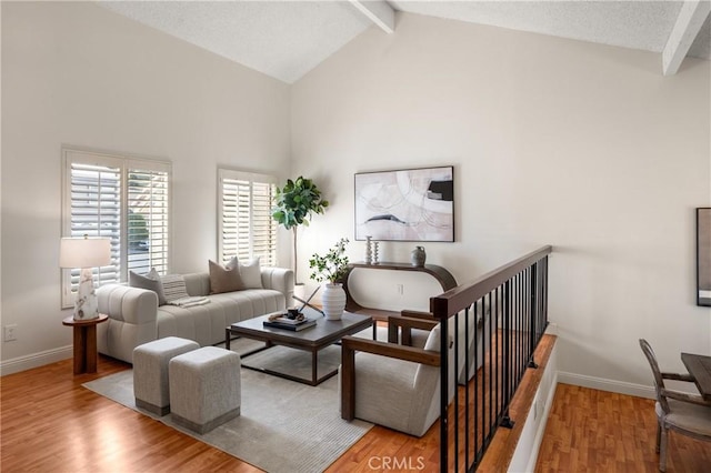 living room with beamed ceiling, light wood-type flooring, and high vaulted ceiling