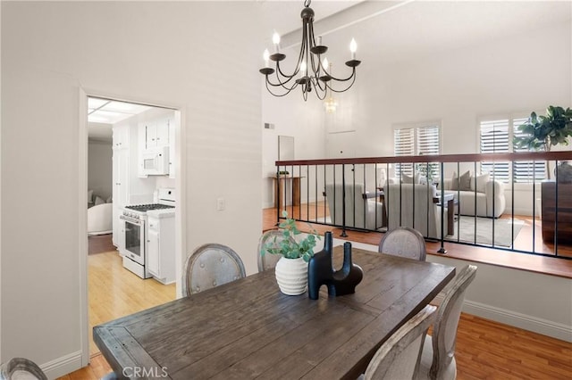 dining space with a notable chandelier and light hardwood / wood-style flooring