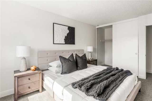 carpeted bedroom featuring a textured ceiling and a closet