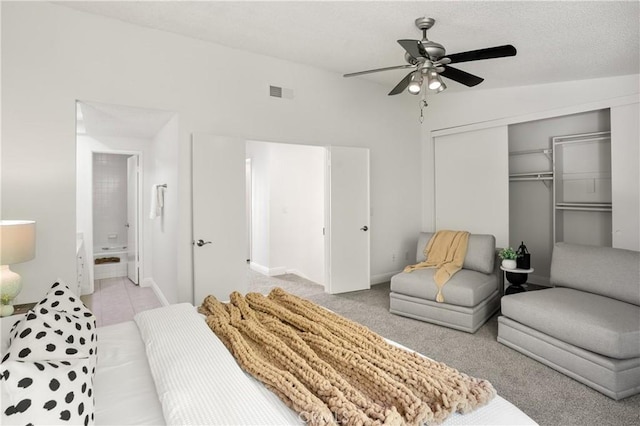 carpeted bedroom featuring ceiling fan, a closet, ensuite bathroom, and lofted ceiling