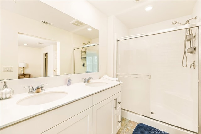 bathroom featuring walk in shower and vanity