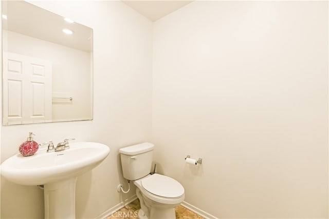 bathroom featuring tile patterned flooring, toilet, and sink