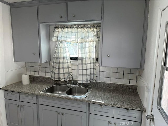 kitchen with gray cabinets, decorative backsplash, and sink