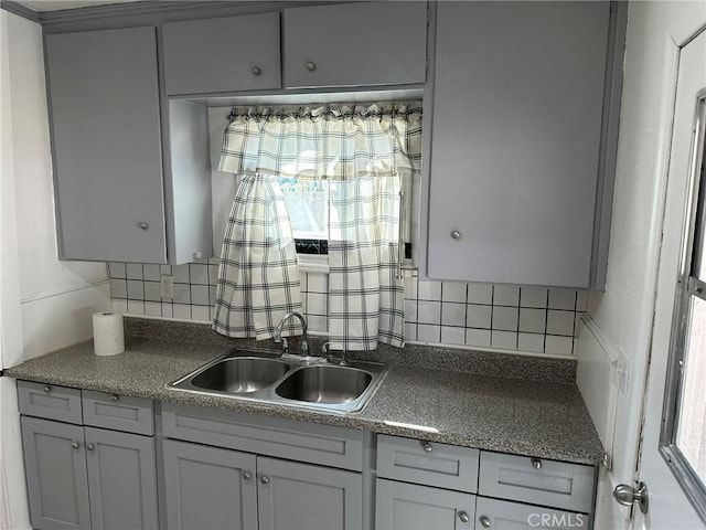 kitchen with gray cabinets, sink, and backsplash