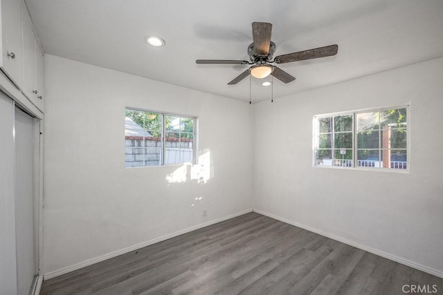 spare room with dark hardwood / wood-style floors and ceiling fan