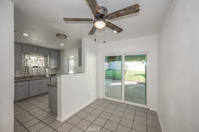 kitchen featuring sink, decorative backsplash, gray cabinets, ceiling fan, and light tile patterned floors