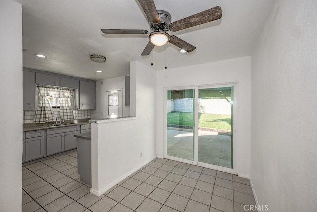 kitchen with sink, decorative backsplash, gray cabinets, and a wealth of natural light