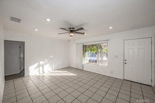 tiled spare room with ceiling fan