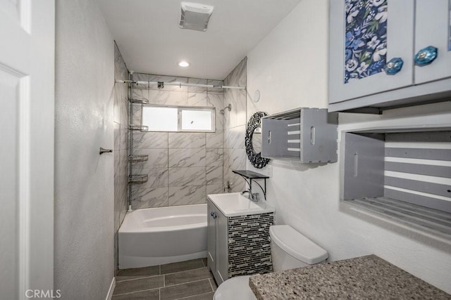 full bathroom with tiled shower / bath combo, toilet, and vanity