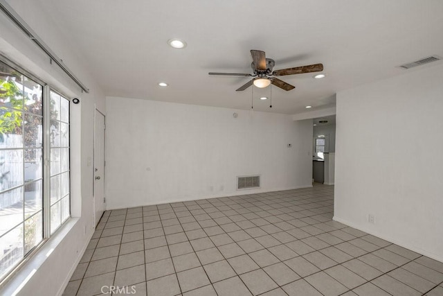 spare room featuring ceiling fan, plenty of natural light, and light tile patterned flooring