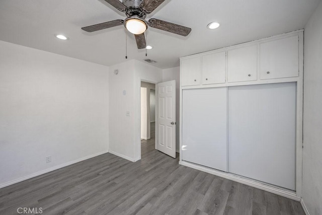 unfurnished bedroom featuring ceiling fan, light wood-type flooring, and a closet