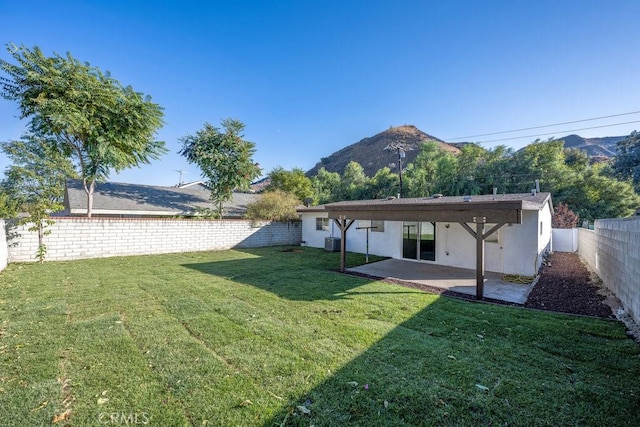 view of yard with a mountain view, a patio, and central AC